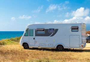 A caravan & Motorhome parked on a cliff near the sea. 